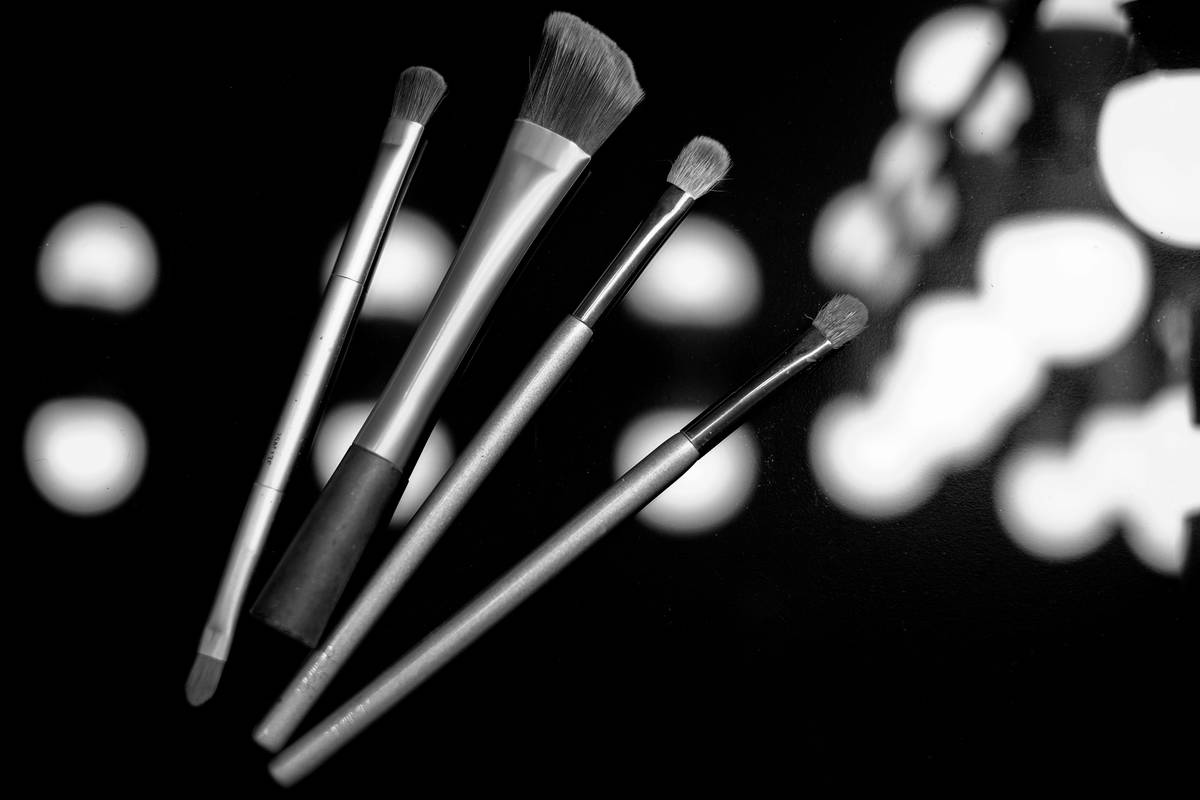 Close-up of a damp cosmetic blending applicator smoothly blending liquid foundation on cheek